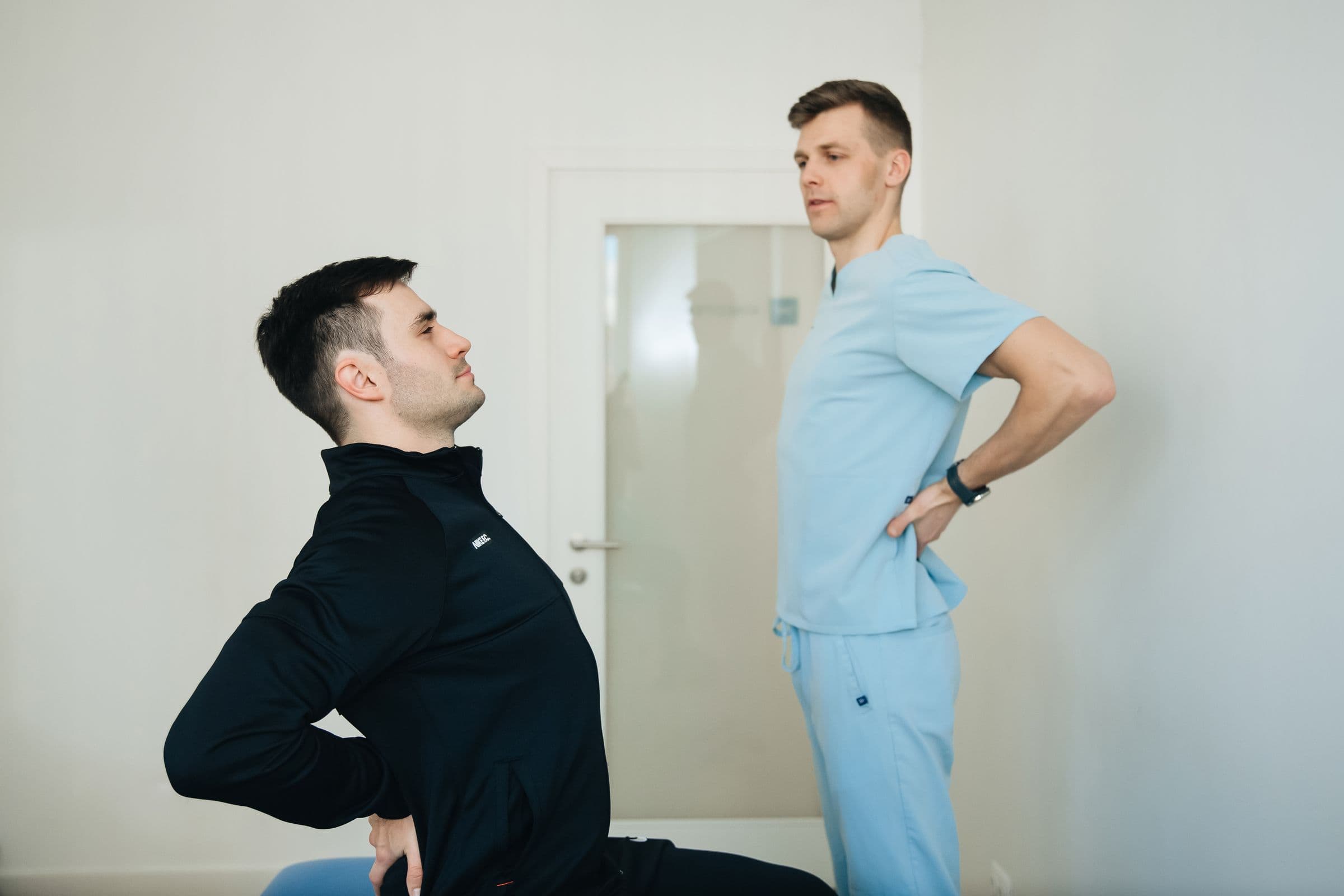 Pacient care execută o extensie a trunchiului, sub îndrumarea unui fizioterapeut